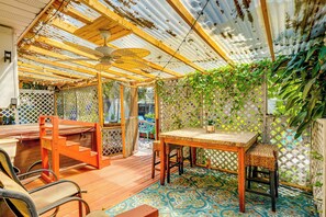 Relax in a serene outdoor space surrounded by lush greenery and a patio area with a table and chairs.