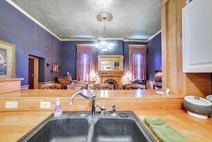 A kitchen with a double sink, wooden countertops, and a chandelier.