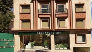 A building with a sign reading 'Signature Inn.' - Signature inn Mcleodganj (Dharamshala)