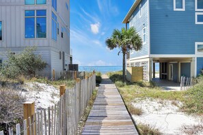 A wooden boardwalk leading to a beachside building with a view of the ocean. - Steps to Beach, Gulf Views, Community Pool, Sleeps 14! Adventure Time🌊 (Cape San Blas)