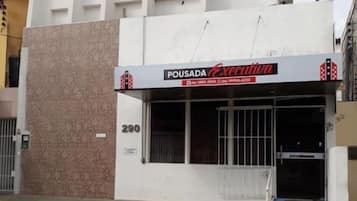 Um edifício com uma placa que diz “POUSADA Executiva” e uma rampa acessível para cadeiras de rodas.