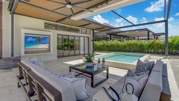 Ein moderner Außenbereich mit Pool, bequemen Sitzgelegenheiten und einem Deckenventilator.