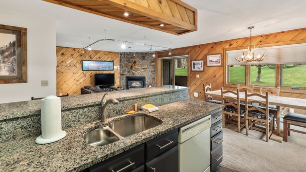 A kitchen with granite countertops, a built-in stove, and a stone backsplash.