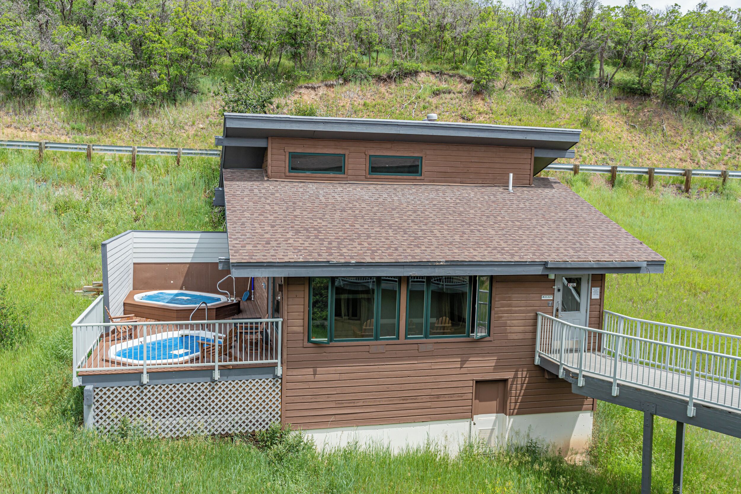 Ein zweistöckiges Haus mit einer Terrasse und einem Whirlpool.