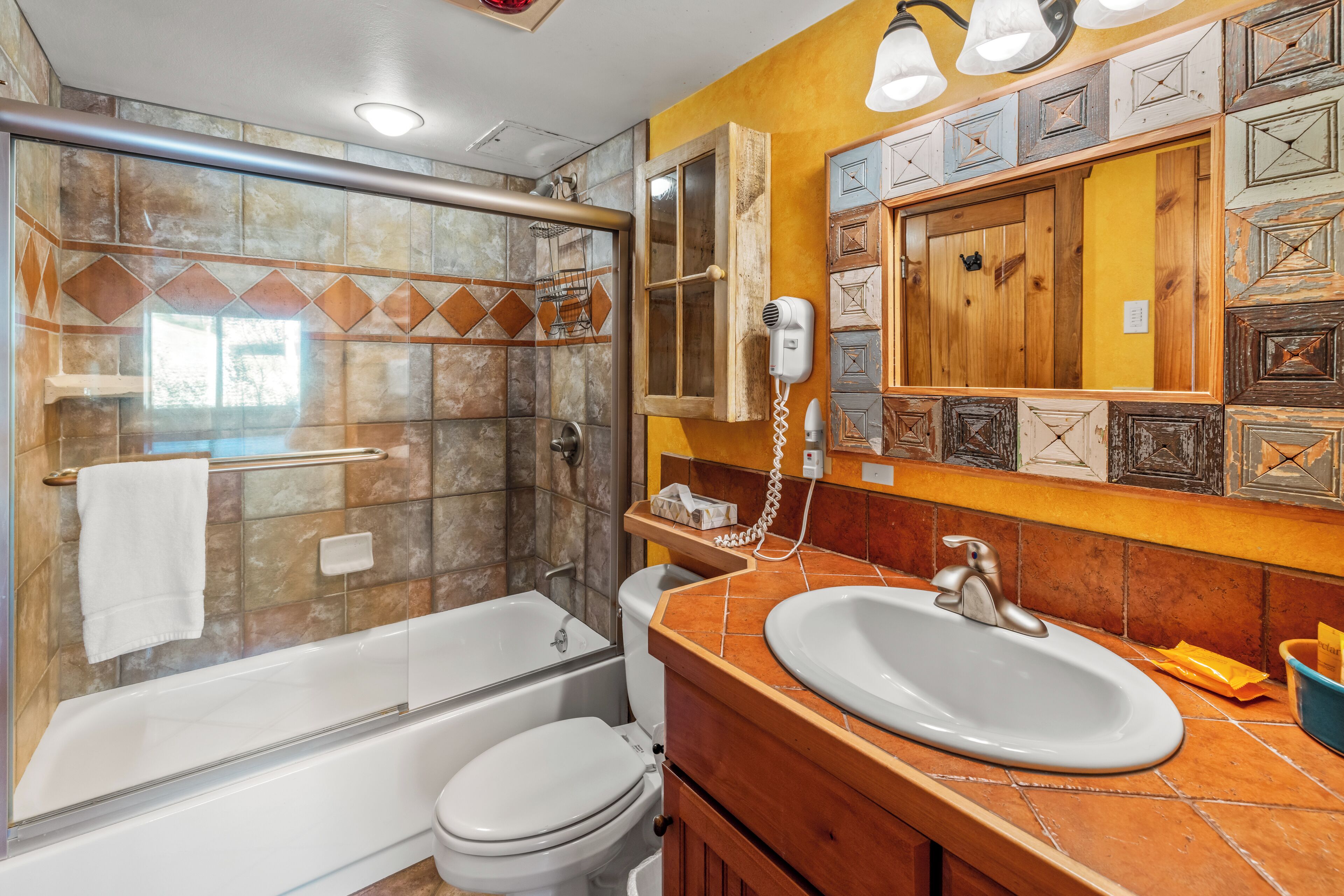 A bathroom with a shower, toilet, and sink.