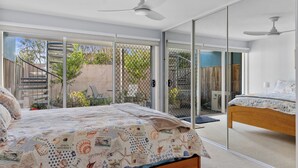 A bedroom with a bed, a second bed, and a ceiling fan. - Osbourne walk to beach (Cowes)