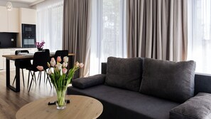 Un salon moderne comprenant un canapé, une table basse et un coin repas avec des chaises et une table.