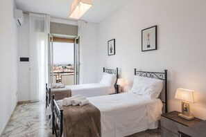 A hotel room with two beds, a view of the city, and a balcony. - Casa Adda by Wonderful Italy - Marte (Syracuse)