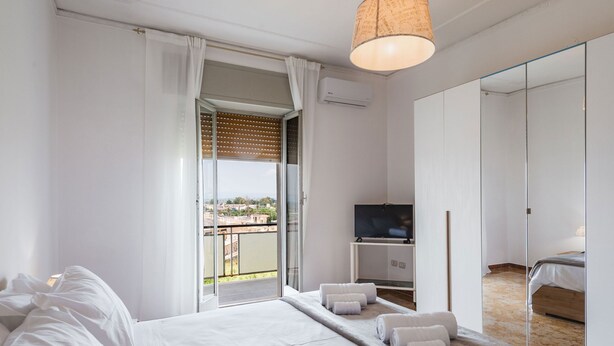 A modern hotel room with a large bed, a TV, a balcony with a view, and a wardrobe. - Casa Adda by Wonderful Italy - Marte (Syracuse)