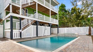 A two-story house with a swimming pool and a white picket fence. - Walk to Beach: 7BR House w/ Private Pool & Hot Tub (Surfside Beach)