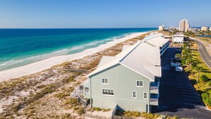 Un hotel frente a la playa con un edificio largo y esbelto que da a vista al océano.