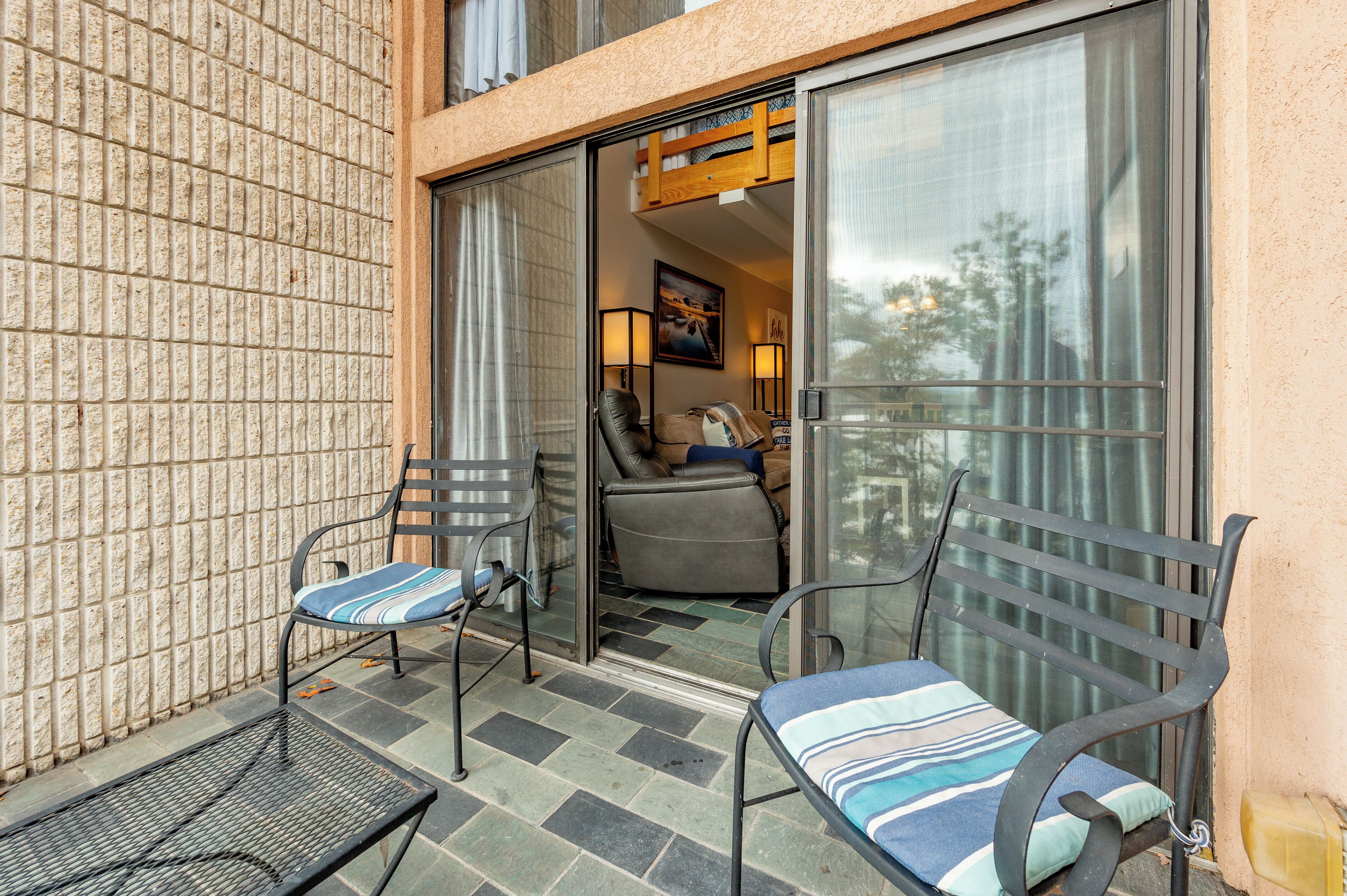 A balcony with two chairs, a table, and a sofa.