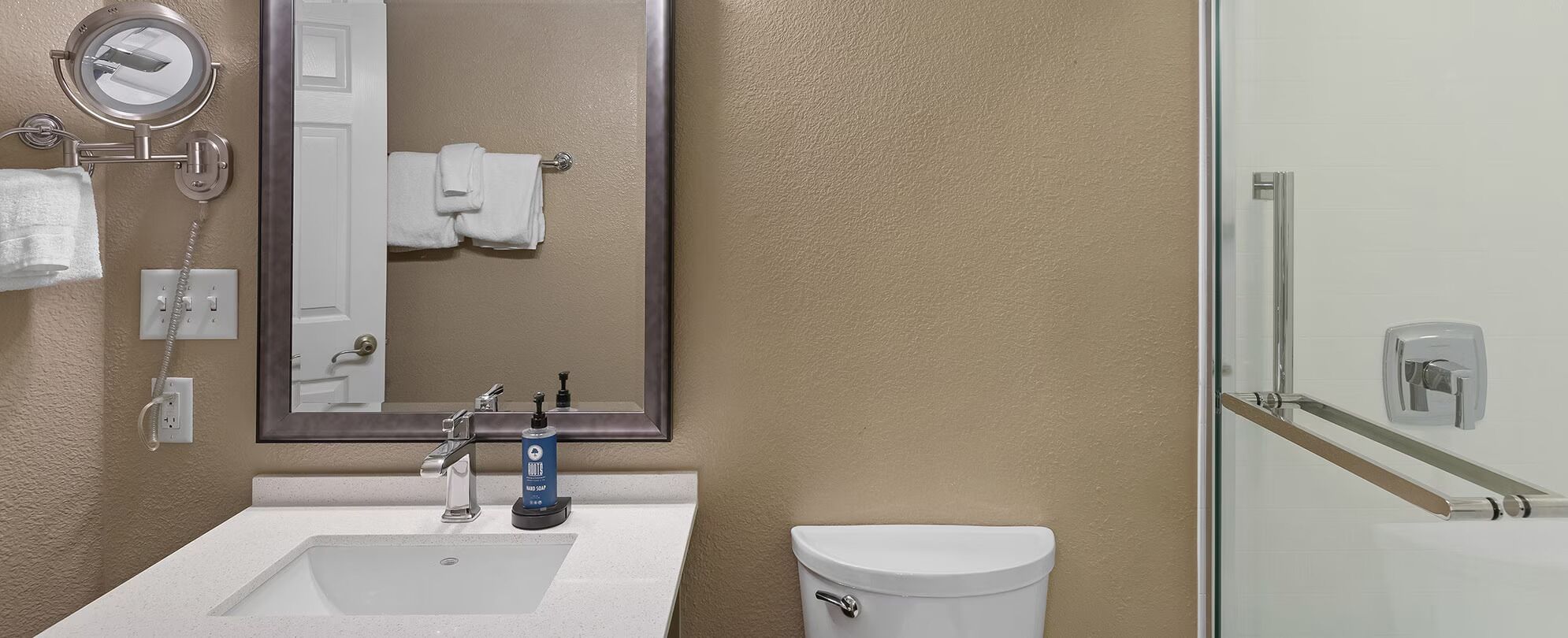 Une salle de bain équipée d’un lavabo, d’un miroir, d’un porte-serviettes et de toilettes.