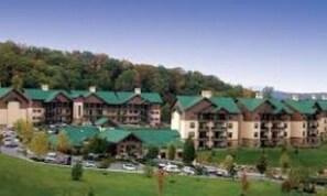 Een rij meerverdiepinggebouwen met groene daken, waarschijnlijk onderdeel van een hotel of resort.