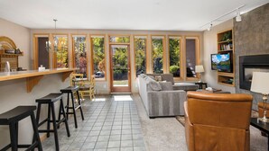 A modern living room with a sofa, a brown leather chair, a TV, and a fireplace. - Mtn Views and a Short Walk to Gondola, SV13E (Vail)
