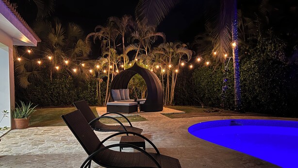 An outdoor seating area with lounge chairs and a pool.
