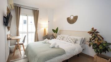 A neatly arranged bedroom with a bed, a desk, and a chair.