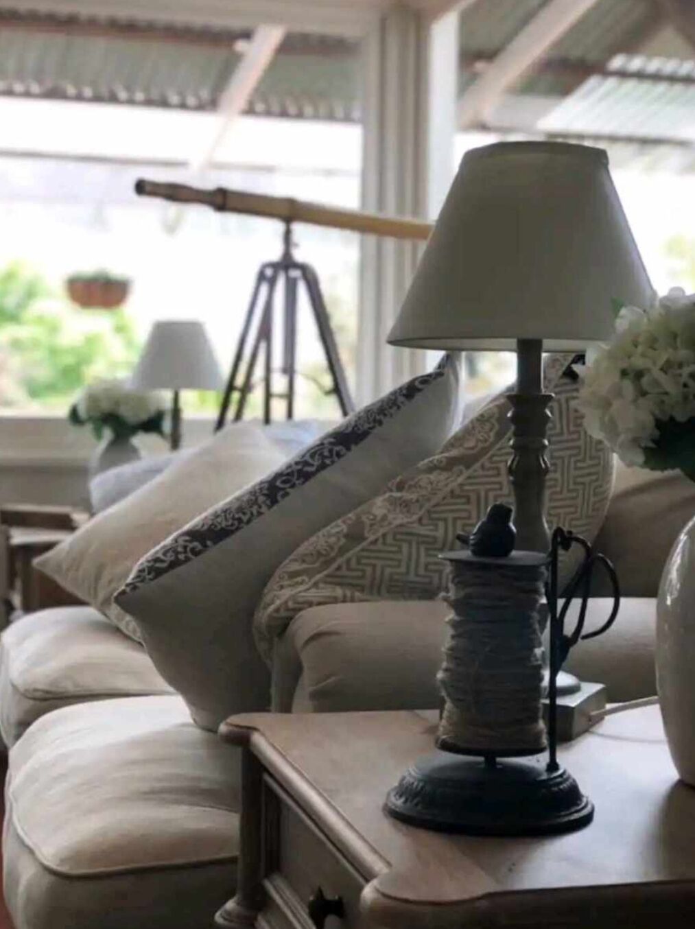 A cozy living room with a sofa, a lamp, and decorative pillows.