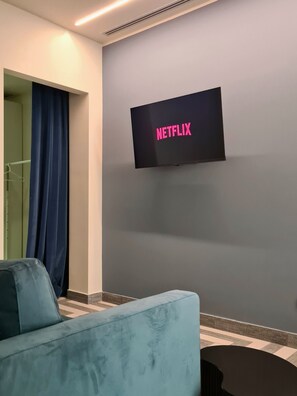 Habitación doble Deluxe | Área de sala de estar | Televisión de 42 pulgadas con canales digitales