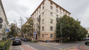Ein mehrstöckiges Wohngebäude mit beiger Fassade, Balkonen und einem Parkschild.
