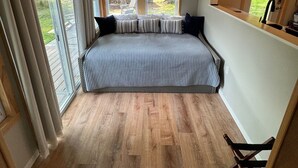 Un dormitorio con una cama grande, una ventana con persianas, techo de madera y vistas al exterior.