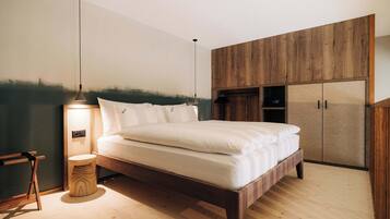 A bedroom with a wooden bed frame, a bedside table with a lamp, and a wardrobe with a wooden finish.