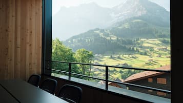A room with a large window overlooking a mountainous landscape.
