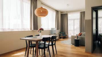 Un espacio moderno para vivir con comedor, sofá y un amplio ventanal con cortinas.