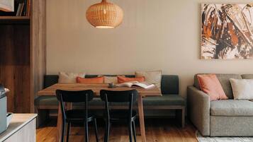 A cozy living space with a wooden dining table, two chairs, a sofa, and a couch.