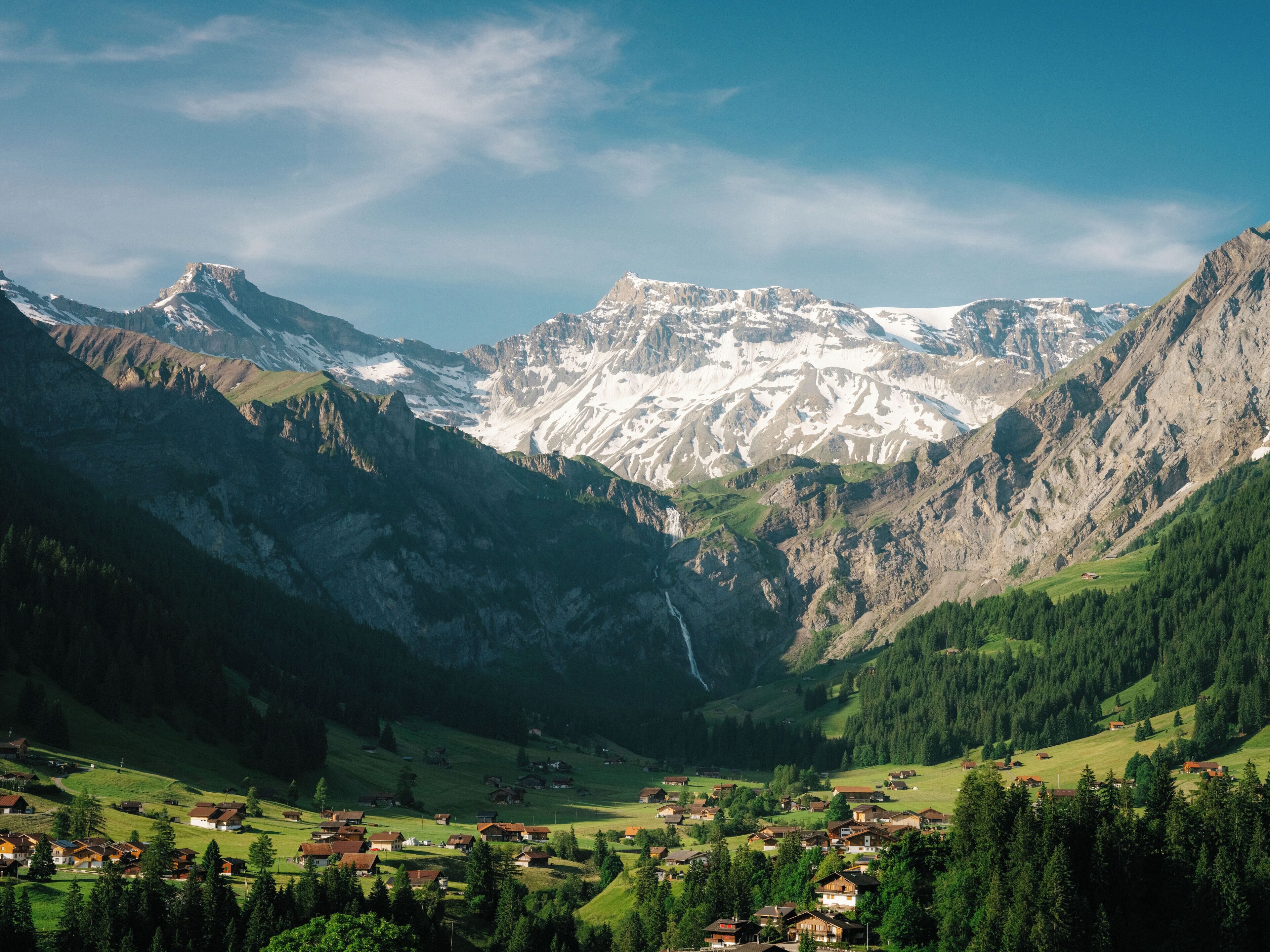 Eine Berglandschaft mit einem Tal und einem kleinen Dorf.