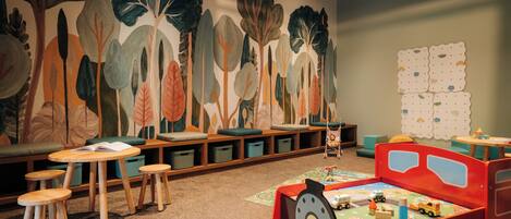 A children's play area with a train bed, seating, and storage bins.