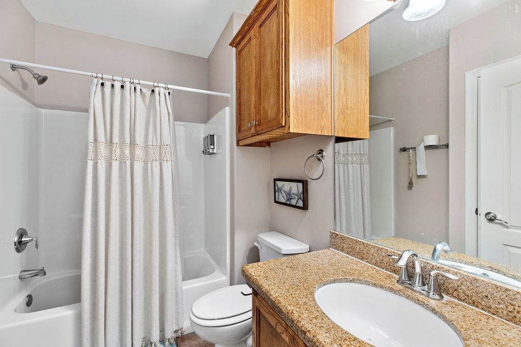 A bathroom with a bathtub, toilet, and sink.