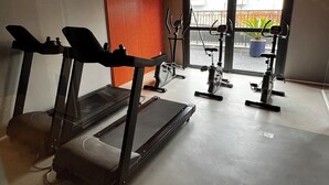 Een sportschool met loopbanden, elliptische trainers en hometrainers.