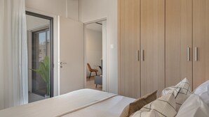 Un dormitorio con cama, armario y puerta que da a un baño.