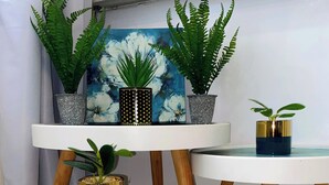 A round table with a blue marble top, two potted plants, and a painting with white flowers. - 73 Fairway Gardens Cozy 2-bedroom apartment in lovely Rendezvous with AC, WiFi (Rendezvous)