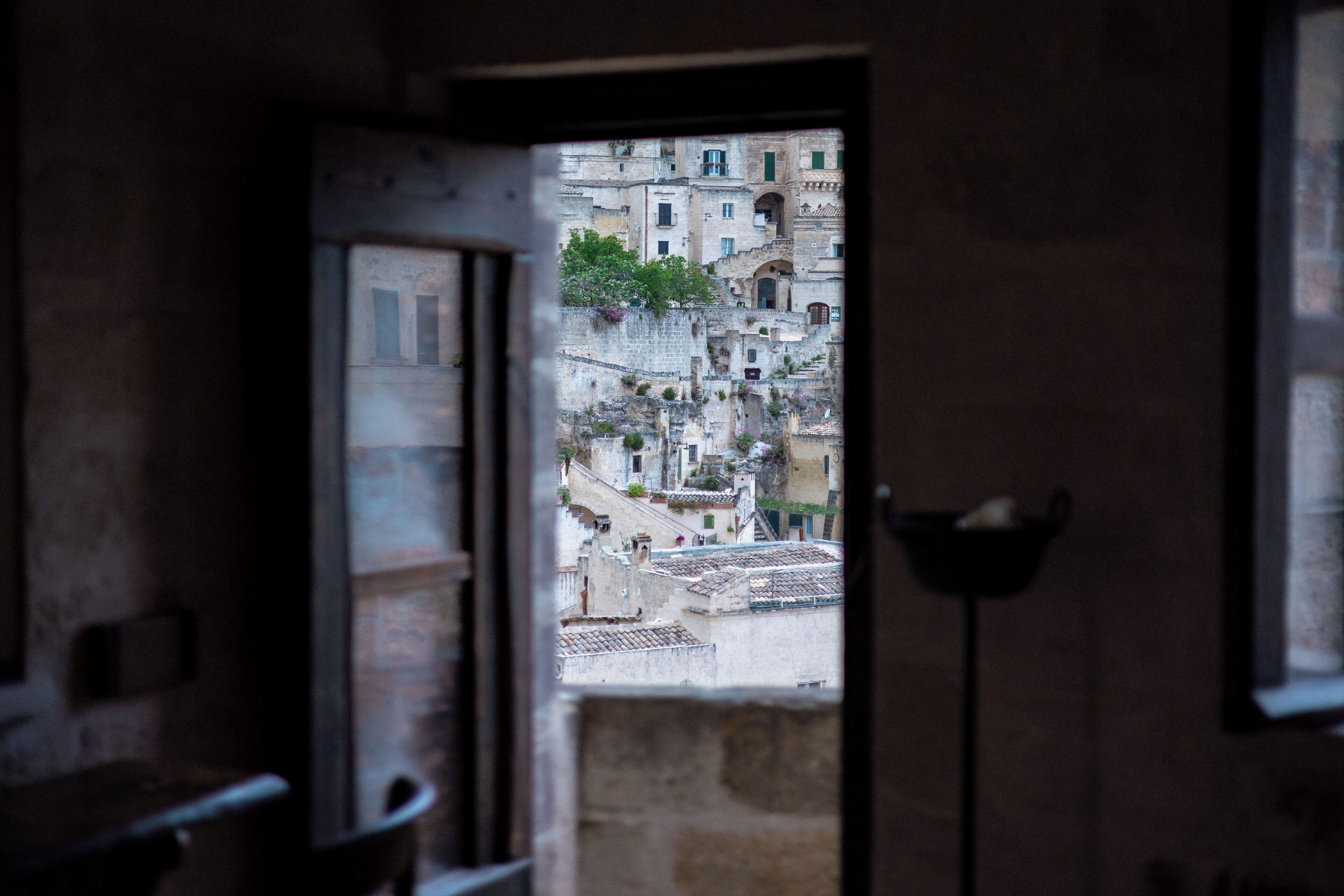 A view through a doorway of a building with multiple balconies and a stone facade.
