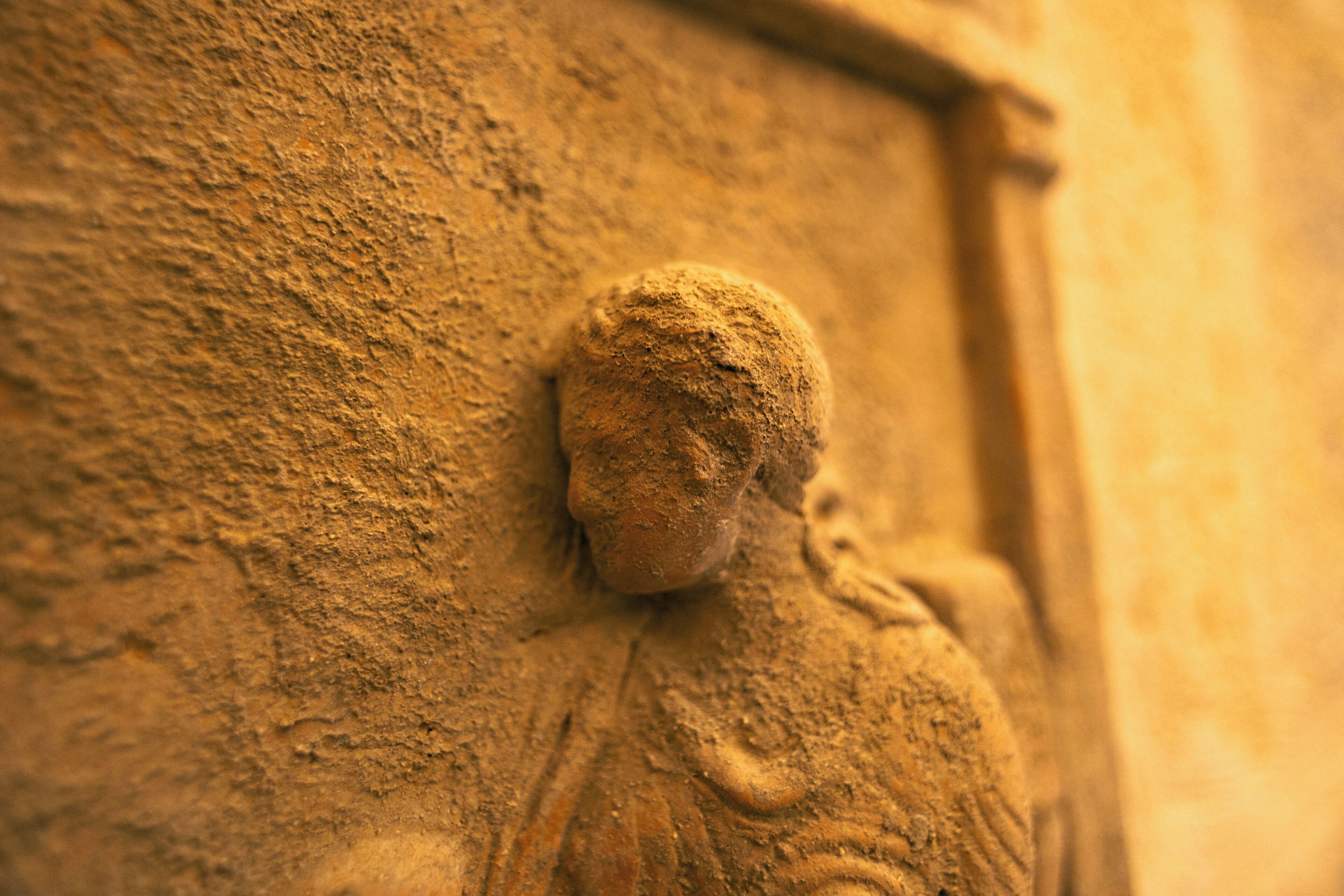 A close-up of a textured wall with a relief sculpture.