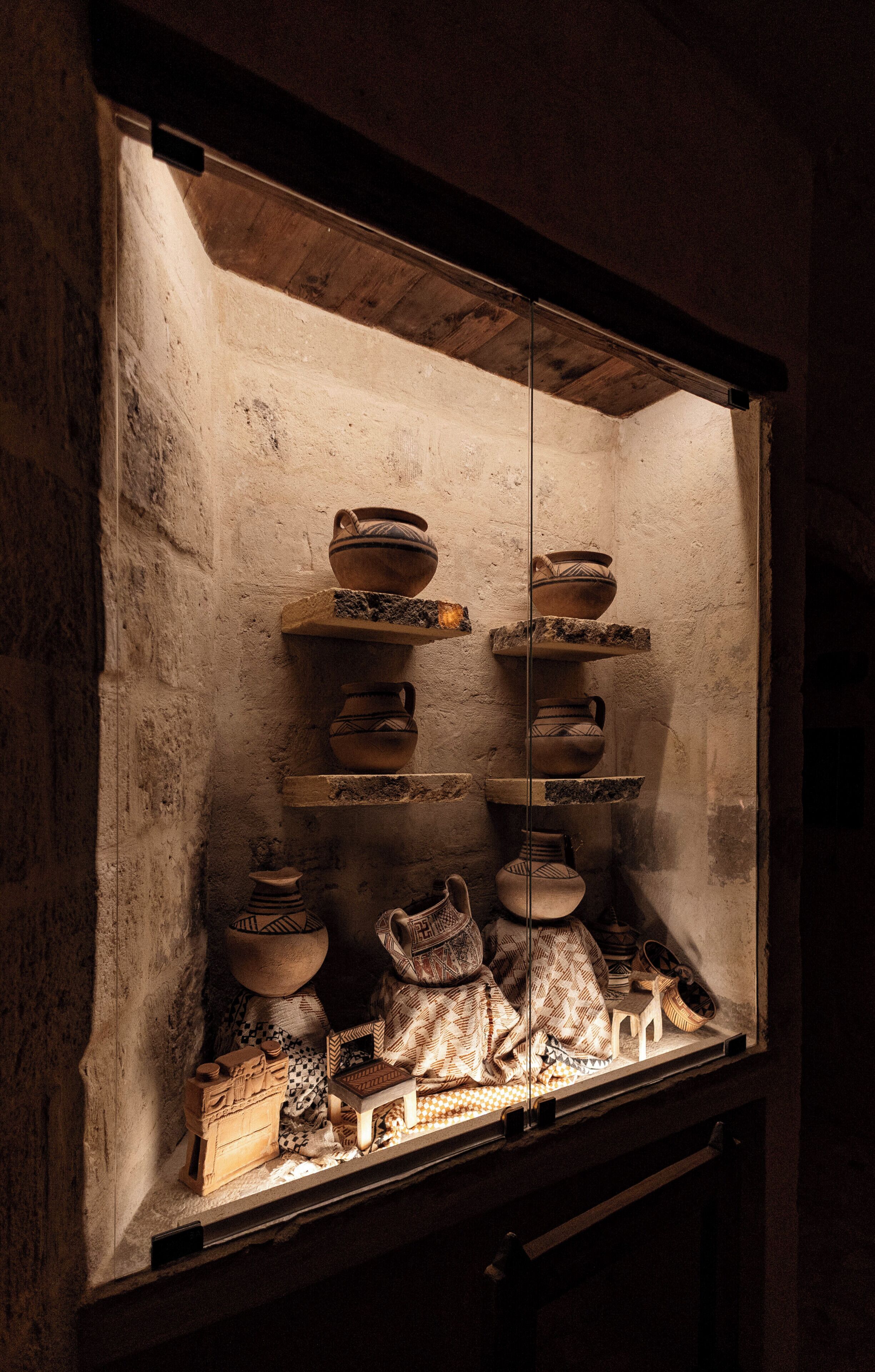 A display case with pottery and textiles.
