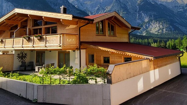 A wooden chalet with a balcony, surrounded by mountains. - Apartment in Leutasch Near Ski Trails (Leutasch)