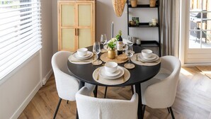 A dining area with a round table set for four, surrounded by four chairs. - Cozy Villa w/ Sauna and BBQ (Hattemerbroek)