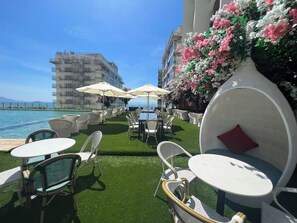 Relax in style with a sea view, surrounded by comfortable seating and lush greenery.