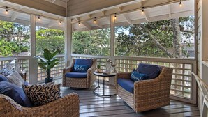 A covered porch with wicker furniture, a ceiling fan, and string lights. - Great Cottage at Hidden Dunes with Free Seasonal Beach Chair Setup! (Miramar Beach)