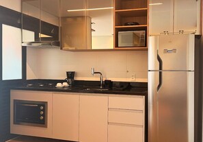 Apartment | Private kitchen | Full-size fridge, microwave, cookware/dishes/utensils - Movinn Expand - Pinheiros (São Paulo)