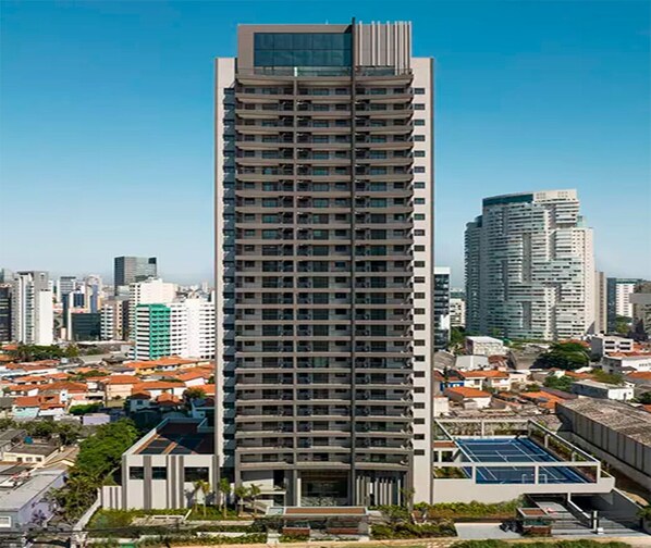 Un grattacielo con diversi piani, circondato da altri edifici e un cielo sereno.