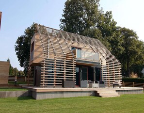A modern house with a sloped roof, large windows, and a wooden exterior. - Luxurioeses Chalet in Wendorf (Kuhlen-Wendorf)