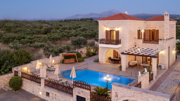 A two-story stone house with a swimming pool, outdoor seating, and a view of the surrounding landscape. - Holiday Home in Arkadi With Private Pool (Rethymno)