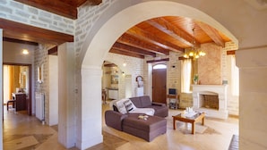 A spacious living area with a fireplace, a sofa, and a coffee table. - Holiday Home in Arkadi With Private Pool (Rethymno)