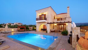 A two-story house with a swimming pool, outdoor seating, and a view of the landscape. - Holiday Home in Arkadi With Private Pool (Rethymno)