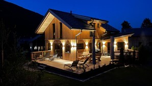 A two-story wooden house with a deck, outdoor seating, and a barbecue area. - Attractive Chalet With Sauna (Sankt Georgen am Kreischberg)