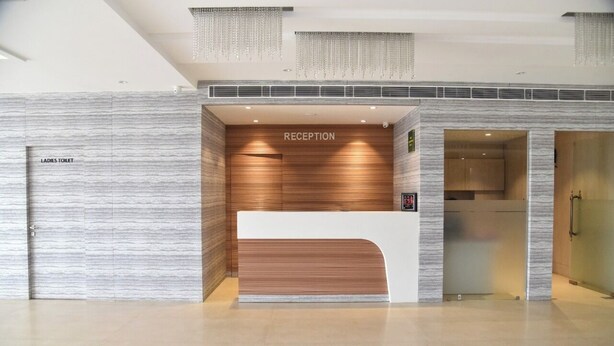 Un espace d’accueil au design moderne, comprenant un comptoir de réception et une enseigne indiquant « RÉCEPTION ».